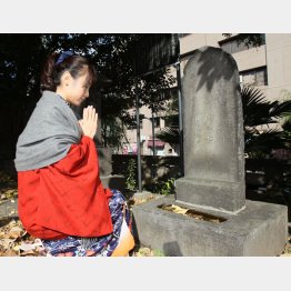 間新六の墓に手を合わせる堀口さん（築地本願寺）／（Ｃ）日刊ゲンダイ