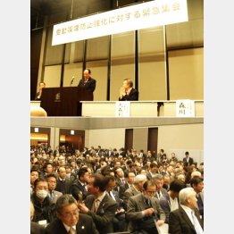 決議を読み上げる森川氏（上）と満席の会場（下）（Ｃ）日刊ゲンダイ