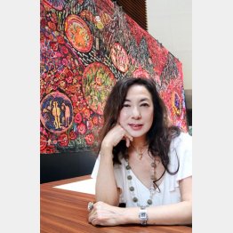 大作「薔薇の神曲」を背景に（Ｃ）日刊ゲンダイ