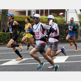 ランニングポリスを支える（Ｃ）日刊ゲンダイ