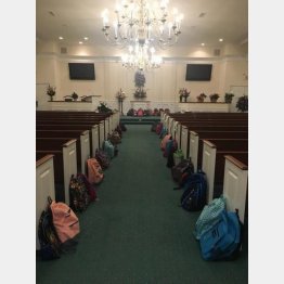 教会の通路に並べられたバックパック（ジョンソンさんのツイッターより）
