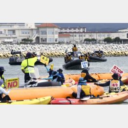 沿岸部の護岸工事付近で、カヌーから抗議の声を上げる人々（Ｃ）共同通信社