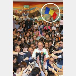 沖縄県知事選に圧勝し、報道陣に囲まれる玉城デニー氏（円内が三色旗）／（Ｃ）日刊ゲンダイ