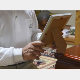 自殺した男性職員の写真を手に岡山県内の自宅で取材に応じた父親（Ｃ）共同通信社