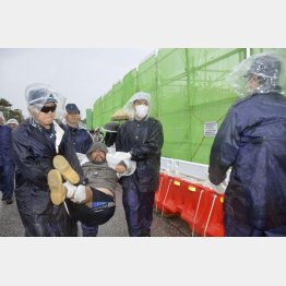 辺野古資材搬入再開で市民は反対（米軍キャンプ・シュワブのゲート前で、機動隊員に排除される反対派の市民）／（Ｃ）共同通信社