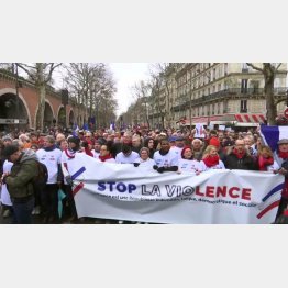 「暴力はやめろ」と書かれた横断幕とともに抗議の行進／（Ｃ）ロイター