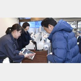 鮮魚店でキャッシュレス決済を体験する安倍首相（右）／（Ｃ）共同通信社