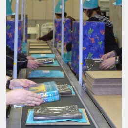 １冊ずつ丁寧に包む（Ｃ）共同通信社