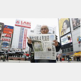 暗い将来へ一直線（天皇陛下の退位日を伝える新聞の号外を読む男性）／（Ｃ）共同通信社