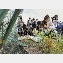 事故現場で手を合わせる親子連れ（Ｃ）共同通信社