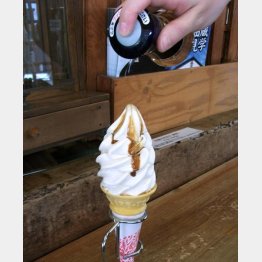 醤油ソフトクリームにさらに醤油を垂らして食べる（Ｃ）日刊ゲンダイ
