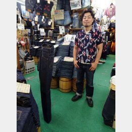 立っている「2kg JEANS」を見つめる酒井隆太さん（Ｃ）日刊ゲンダイ