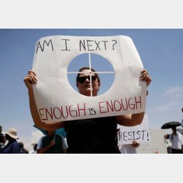 プラカードを掲げて抗議する女性（Ｃ）ロイター