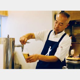 ビールをつぐ重富寛さん（Ｃ）日刊ゲンダイ