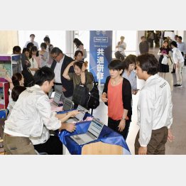 表現の自由まで奪われて（大会ボランティアの共通研修で、受け付けをする参加者）／（Ｃ）共同通信社