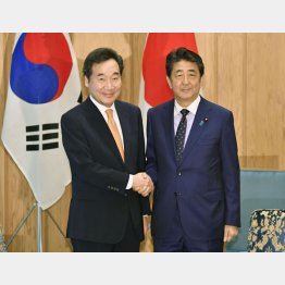 会談前に握手する韓国の李洛淵首相（左）と安倍首相（Ｃ）共同通信社