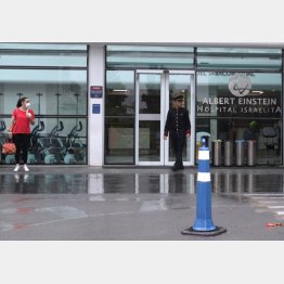 中南米初の感染が確認されたブラジル・サンパウロの病院前に立つマスク姿の女性（Ｃ）ロイター／Rahel Patrasso