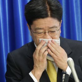 ハンカチで口を覆いながら会見を行う加藤厚労相（Ｃ）日刊ゲンダイ
