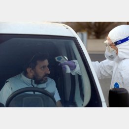 どう見てもパンデミック（スロベニアとイタリアの国境でコロナウイルスのチェックをする作業員）／（Ｃ）ロイター