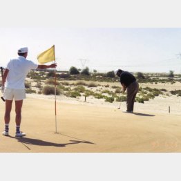 灼熱の砂漠でもプレー（ピンを持つモト冬樹さん）／（提供写真）