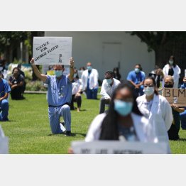 ジョージ・フロイド氏に黙とうを捧げる医療従事者の人たち（Ｃ）ロイター