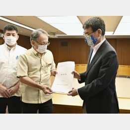 河野防衛相（右）に、日本に入国する米軍人らのＰＣＲ検査を米国に徹底させるよう求める要請書を手渡す沖縄県の玉城デニー知事（中央）／（Ｃ）共同通信社