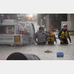 これだけ異常気象や災害が起きているのに…（福岡県大牟田市の冠水した道路で車が動かなくなり、救助される男性＝7日）／（Ｃ）共同通信社
