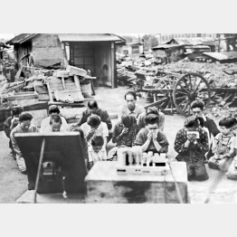 焼け跡で玉音放送をラジオで聞き、涙を流す戦災者たち（1945年8月15日＝場所不明）／（Ｃ）共同通信社