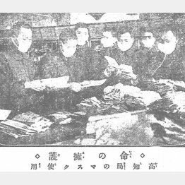 1920（大正9）年1月18日付の土陽新聞は「命の擁護　高知局のマスク使用」という見出しで、マスク姿で郵便物を仕分ける郵便局員の写真を掲載。100年を経て、今の社会と光景が重なる（Ｃ）高知新聞社／共同イメージズ
