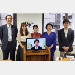 シンポ参加者と高田明氏（中央モニター）／（Ｃ）日刊ゲンダイ