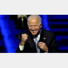 勝利にガッツポーズをするバイデン新大統領（Ｃ）ロイター