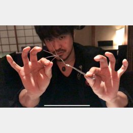 フォークを曲げる大城さん（提供写真） 