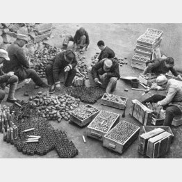 敵から奪った武器弾薬を箱から取り出して分類する中国共産党軍（1937～45年ごろ＝Mary Evans／Grenville Collins Postcard Collection／共同通信イメージズ）