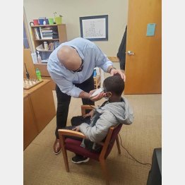 アンソニー君の髪を整えるスミス校長（ルイス・スピークスさんのフェイスブックから）