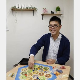 一般社団法人「ボードゲーム」会長 プロボードゲーマー岩田慎太郎さん（大人気ゲーム「カタン」を前に）／（Ｃ）日刊ゲンダイ