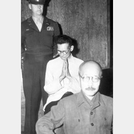 東京裁判初公判で精神錯乱状態となり、祈りのポーズをとる大川周明。この前後に前に座る東條英機の頭を叩く奇行に出た（Ｃ）共同通信社