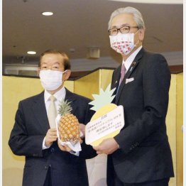 台湾産パイナップルを「日華議員懇談会」会長の古屋元拉致相（右）に手渡す謝長廷・台北駐日経済文化代表処代表＝３月22日、東京都内のホテル（Ｃ）共同通信社