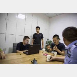 警察で取り調べを受ける川嶋氏。カメラをチェックする警官が撮影。削除されるも帰国後、業者に依頼し復旧（2019年）／（撮影）川嶋久人