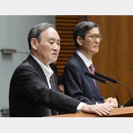 7日、記者会見で質問に答える菅首相。奥は新型コロナウイルス感染症対策分科会の尾身茂会長（Ｃ）共同通信社