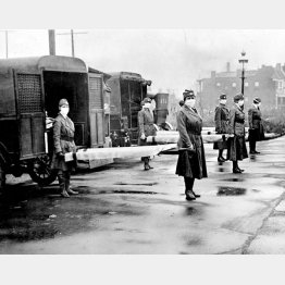 スペイン風邪の流行により、救急車の列の前で担架を持つ赤十字のメンバー（Ｃ）ゲッティ／共同通信イメージズ
