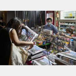 22日、香港の新聞スタンドで蘋果日報を数部購入する女性（Ｃ）ゲッティ＝共同