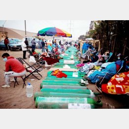 感染患者のために、空の酸素ボンベが満タンになるのを待つ人たち（南米ペルー首都リマ）／（Ｃ）ロイター