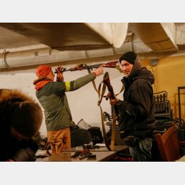 受け取った武器の手入れをする義勇兵たち（Ｃ）ロイター