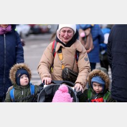 ロシアのウクライナ侵攻から逃れ、子供の隣で泣いている女性（ルーマニア・シレト）／（Ｃ）ロイター