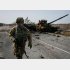 キエフ地域の戦場の最前線、破壊したロシア軍の戦車の前を歩くウクライナ兵（Ｃ）ロイター