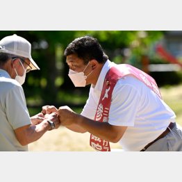 有権者と握手する無所属・芳野正英候補（同氏事務所提供）