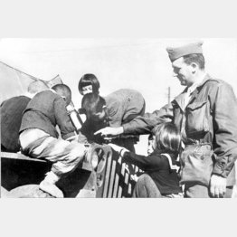 終戦後、子供たちは無心に兵士に群がり、チョコレートやチューインガムをもらった＝1945年（Ｃ）共同通信社