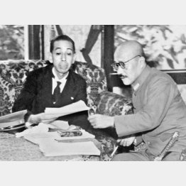 内閣改造で商工相を兼務することになり、前任の岸信介国務相（左）と事務引き継ぎをする東條英機首相（1943年10月9日、商工大臣室）／（Ｃ）共同通信社