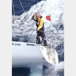 2005年の単独無寄港世界一周中、強い水しぶきを受けながら元気に手を振る堀江さん（Ｃ）共同通信社