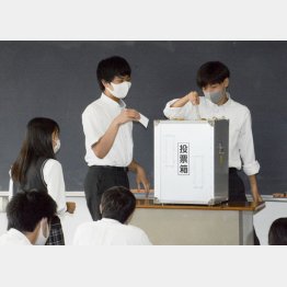 投票できる年齢が18歳に引き下げられて7年。片や被選挙権年齢は今なお見直し無し（模擬投票の授業で1票を投じる高校3年生）／（Ｃ）共同通信社